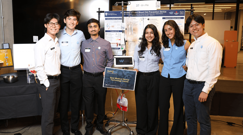 Six members of Team Uroflo pose with their device between them. The device features a bad of red liquid attached to a touch screen.