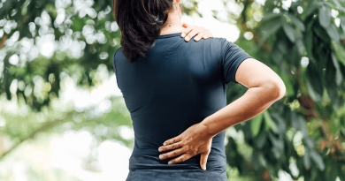 A woman holding her lower back as if in pain.