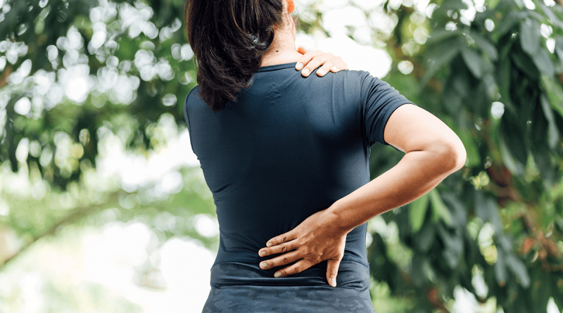 A woman holding her lower back as if in pain.