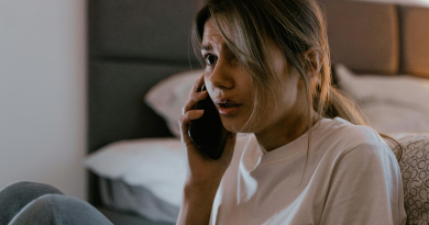 A person talking on the phone with a terrified expression.