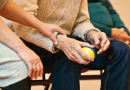 A person holding an older adult's wrist.