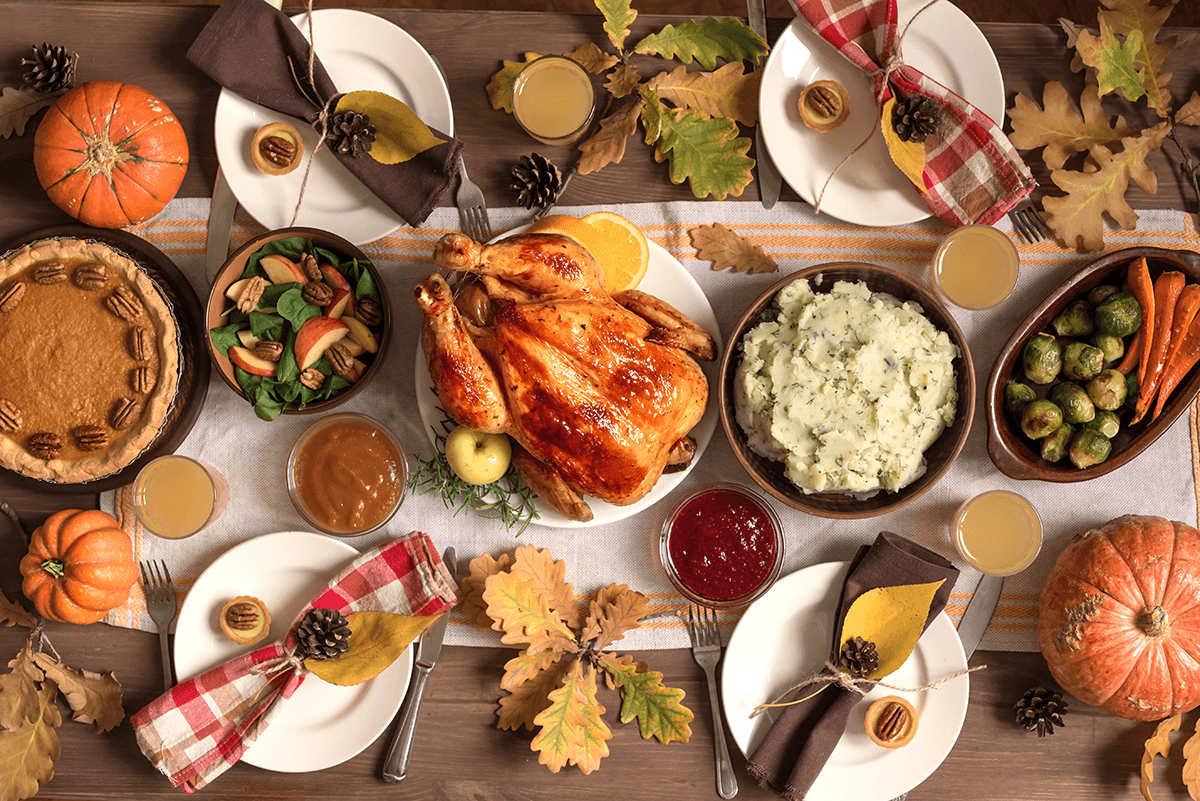 A vibrant and colorful Thanksgiving meal spread with turkey, mashed potatoes, Waldorf salad, pumpkin pie, Brussel's sprouts and carrots.