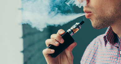 A person exhaling a large smoke cloud from their vape pen.