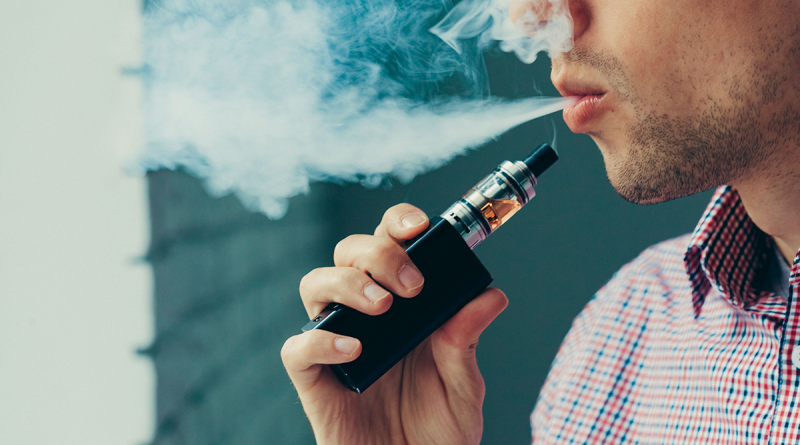 A person exhaling a large smoke cloud from their vape pen.