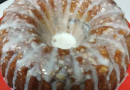 A brown Bundt cake with white icing dripped along the top.