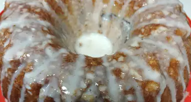 A brown Bundt cake with white icing dripped along the top.