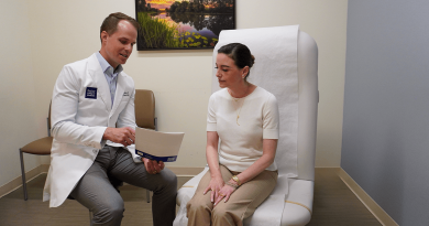 A hopeful-looking doctor showing a seated patient information. The patient is listening intently.