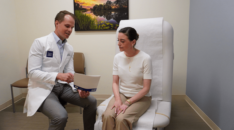 A hopeful-looking doctor showing a seated patient information. The patient is listening intently.