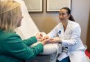 Dr. Christine Yin examines Holly Shilstone's hands in an exam room.