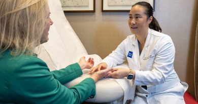 Dr. Christine Yin examines Holly Shilstone's hands in an exam room.