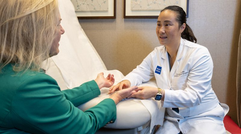 Dr. Christine Yin examines Holly Shilstone's hands in an exam room.