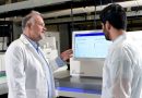 Two doctors looking at research information on a specialized computer.