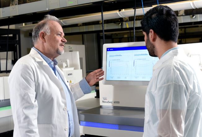 Two doctors looking at research information on a specialized computer.