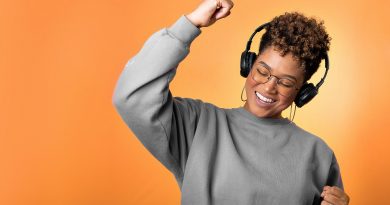 A person wearing headphones pumping a fist happily.
