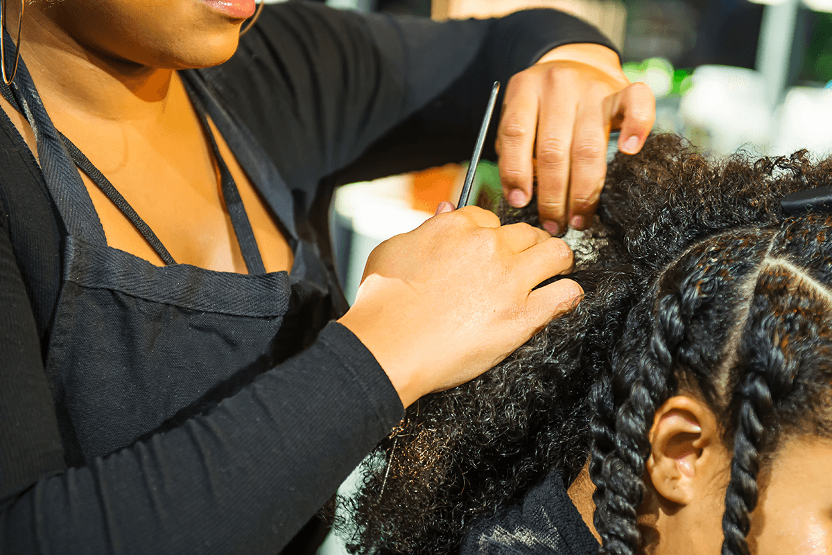 A hair braider working on a person's hair.