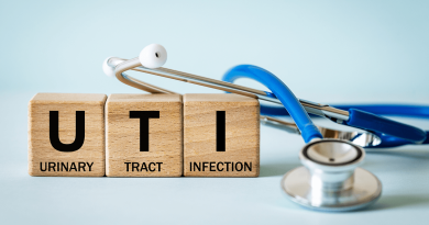 A stethoscope next to three wooden blocks. The blocks have one word each, reading Urinary Tract Infection.