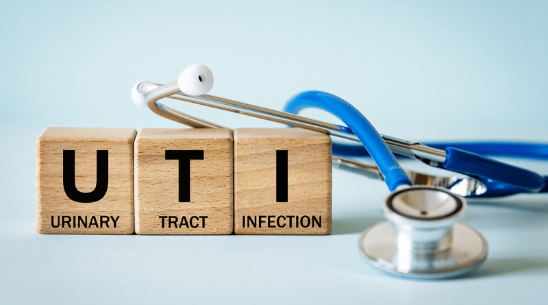 A stethoscope next to three wooden blocks. The blocks have one word each, reading Urinary Tract Infection.