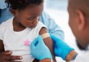 A Band-Aid being applied to a child's arm after they were given a vaccine.