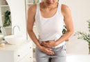 Young woman suffering from cramps in bathroom, closeup