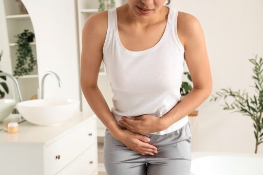 Young woman suffering from cramps in bathroom, closeup