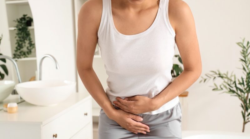 Young woman suffering from cramps in bathroom, closeup