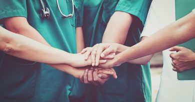Healthcare team joins hands in unity.
