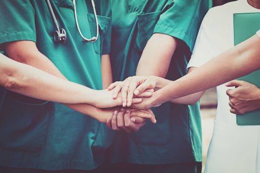 Healthcare team joins hands in unity.