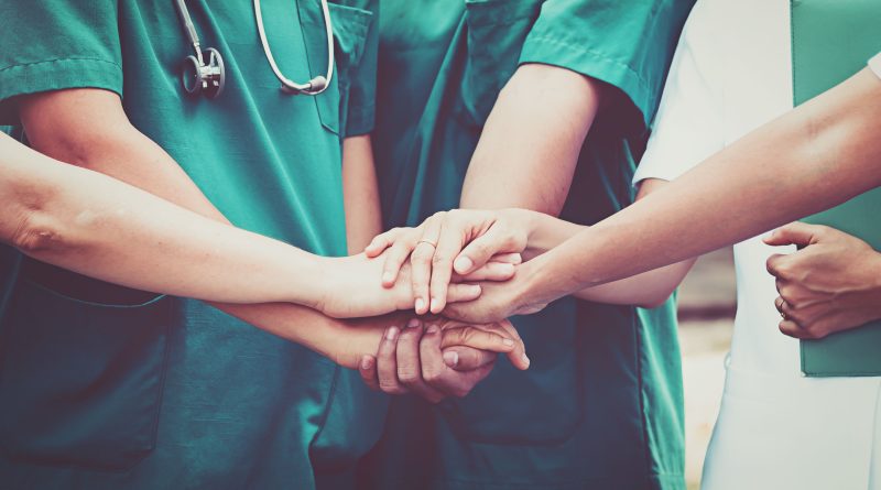 Healthcare team joins hands in unity.