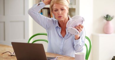 Woman cooling down with a fan.