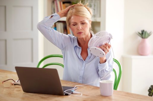 Woman cooling down with a fan.