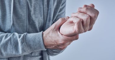 Person holding their wrist due to pain.