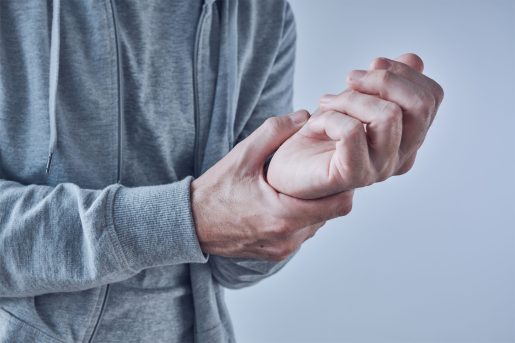 Person holding their wrist due to pain.