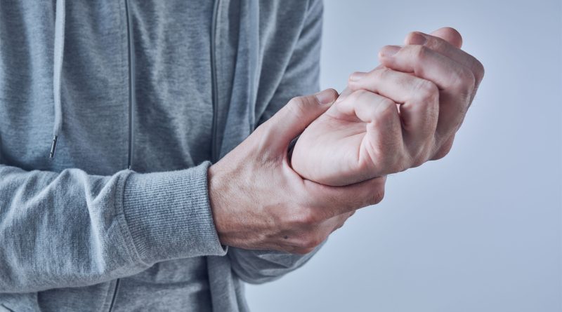 Person holding their wrist due to pain.