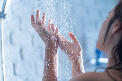 A woman's two hands in the shower.