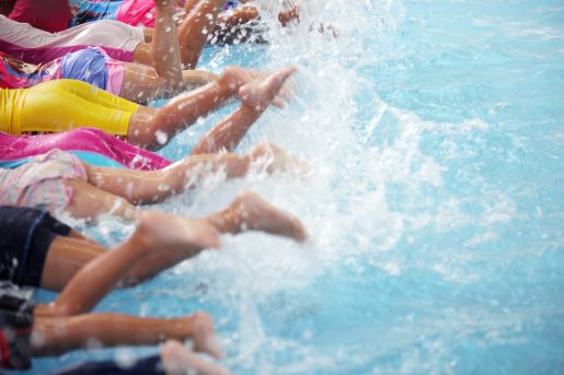 group of children at swimming pool class learning to swim