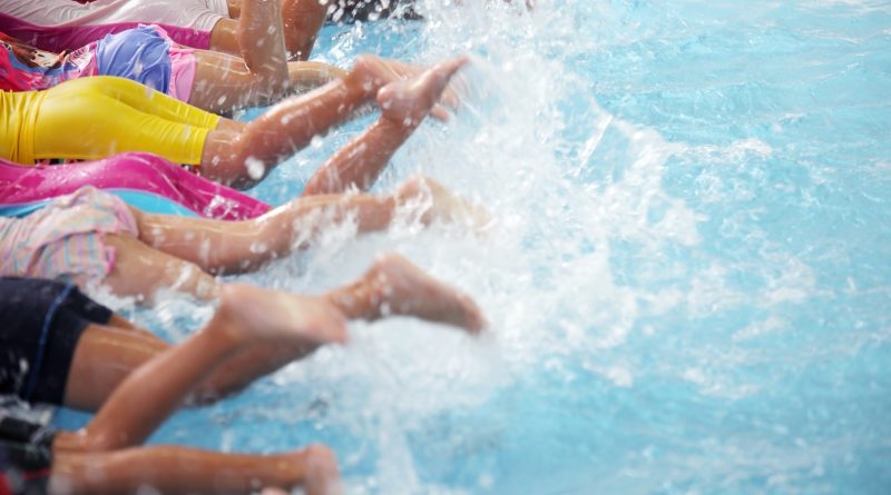 group of children at swimming pool class learning to swim