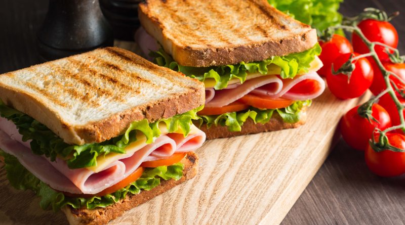 Two sandwiches on a board.