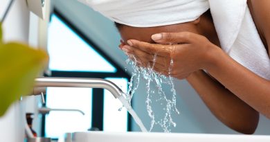 Close up of woman washing her face in the sink at home