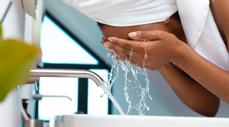 Close up of woman washing her face in the sink at home