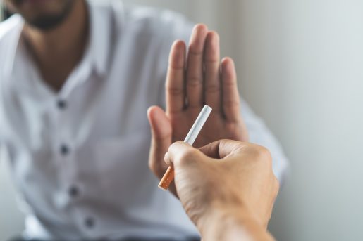 Close up hands of person refusing to smoke cigarette.