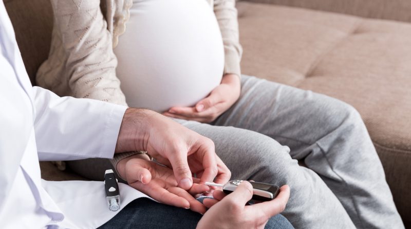 A person is checking blood sugar glucose of pregnant woman at home.