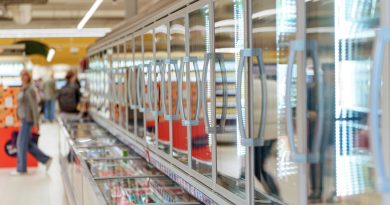 Frozen food aisle with glass door freezers in supermarket