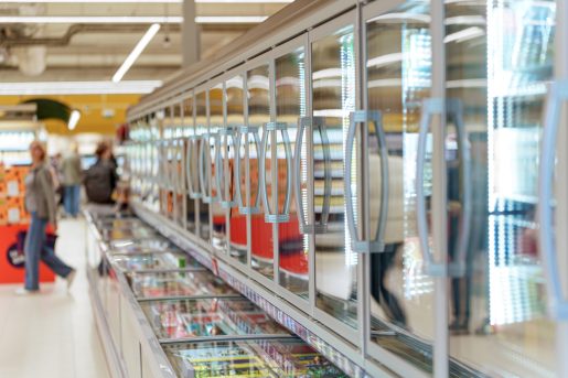 Frozen food aisle with glass door freezers in supermarket
