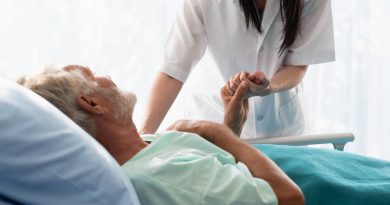 Nurse caring for patient in hospital bed.