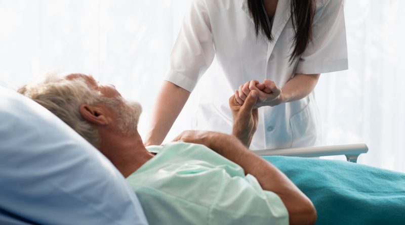 Nurse caring for patient in hospital bed.