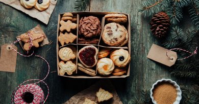 Holiday food background for baking gingerbread cookies in a small paper box decorated on rustic green table. Top view on cookies.