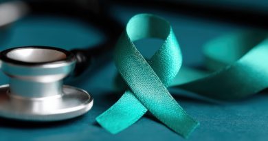 Teal awareness ribbon for ovarian cancer, cervical cancer, sexual assault, and polycystic ovary syndrome near a stethoscope on a table