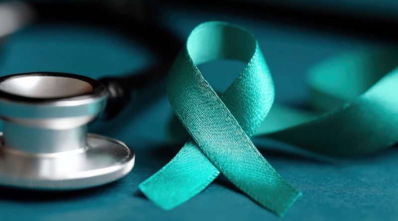Teal awareness ribbon for ovarian cancer, cervical cancer, sexual assault, and polycystic ovary syndrome near a stethoscope on a table