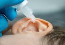 doctor dripping ear drops into patient ear. ear pain and clogged ears concept