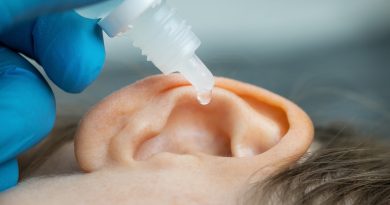 doctor dripping ear drops into patient ear. ear pain and clogged ears concept